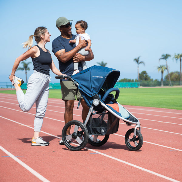 Family stretching next to Bumbleride Speed Jogging Stroller in Supernova
