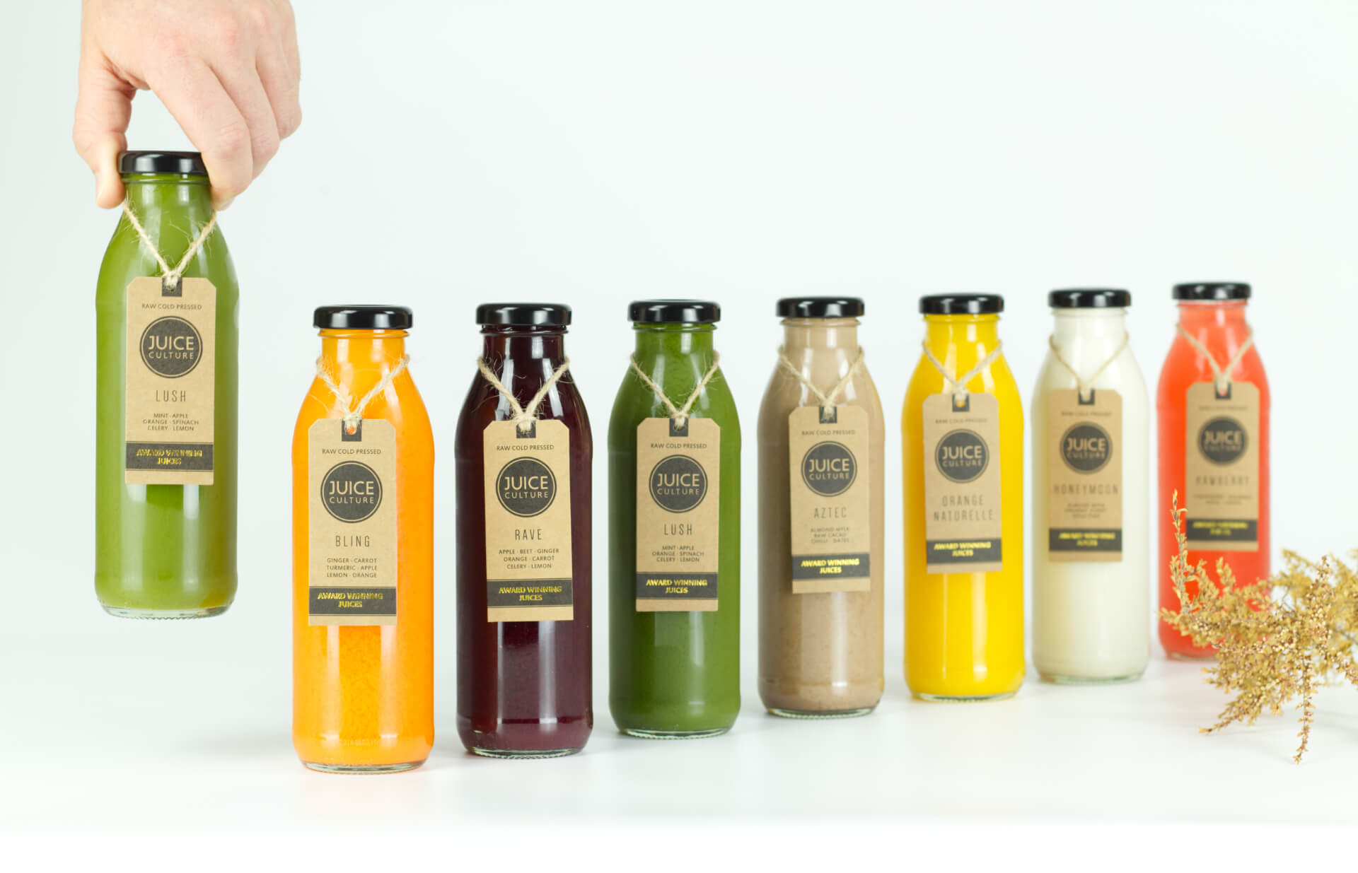 hand choosing juice cleanse glass bottle