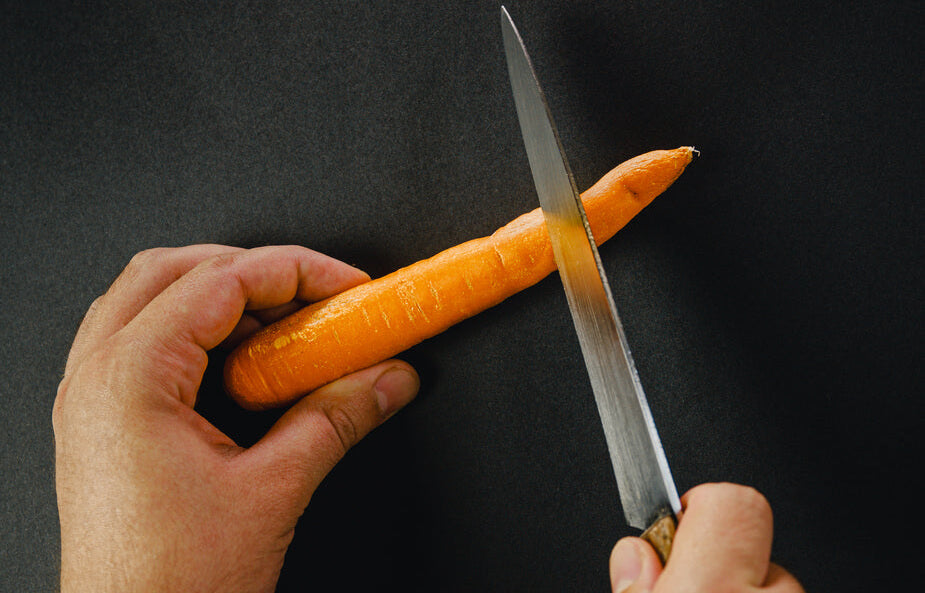 hands preparing carrot for a juice cleanse