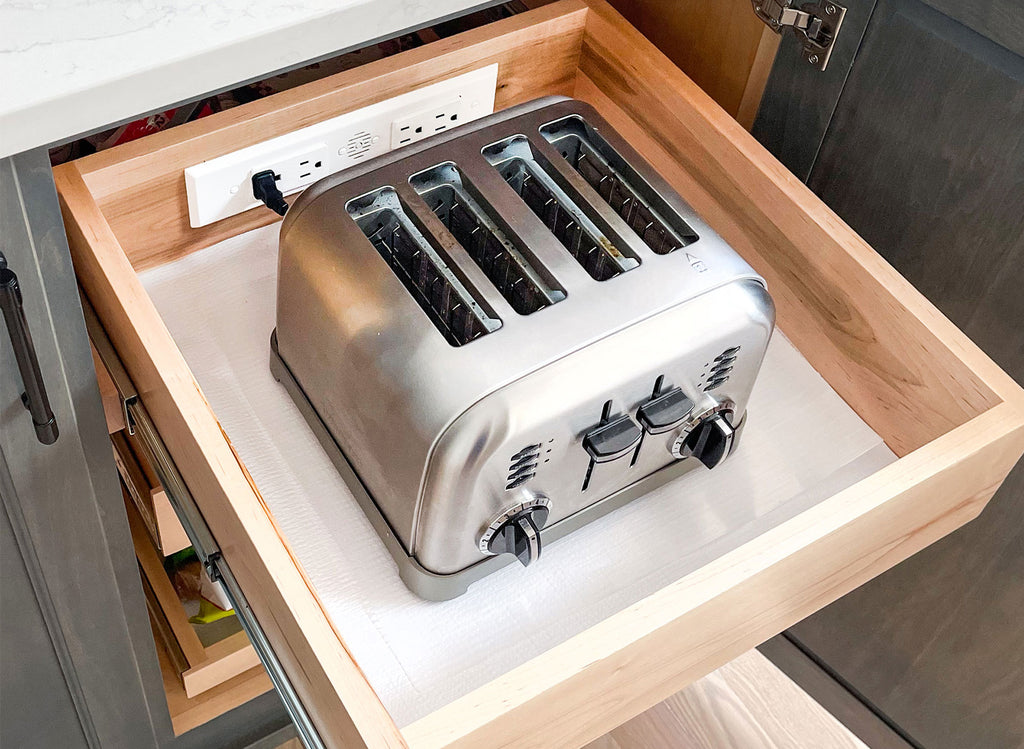A toaster is powered and stored in a kitchen appliance drawer.