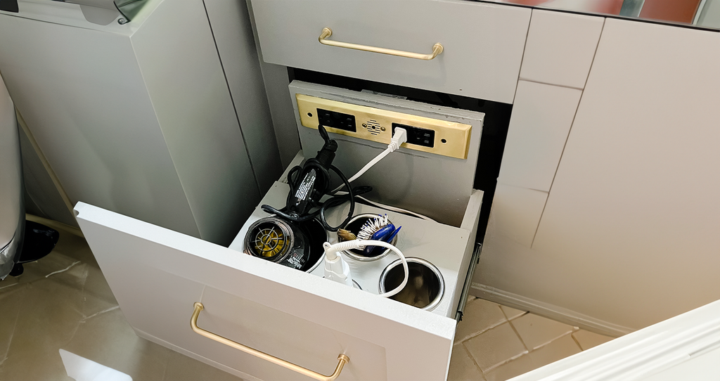 Docking Drawer bathroom vanity drawer installed with in-drawer outlets powering hair styling tools stored in canisters.