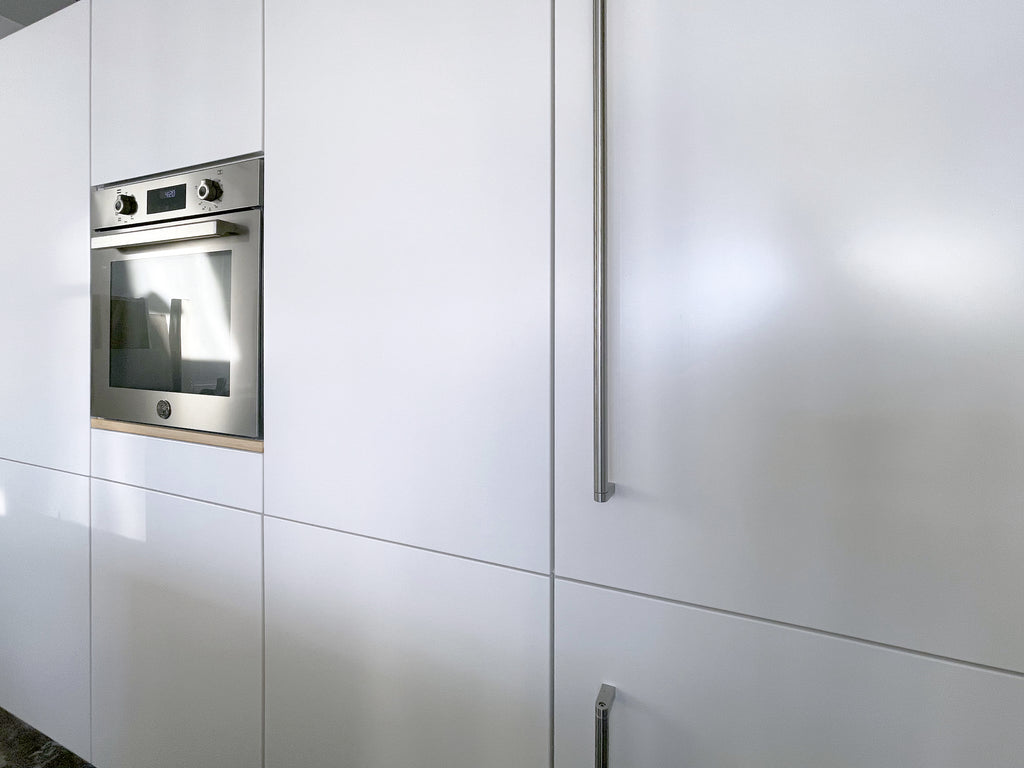 Modern kitchen cabinetry, demonstrating a fully hidden microwave drawer.