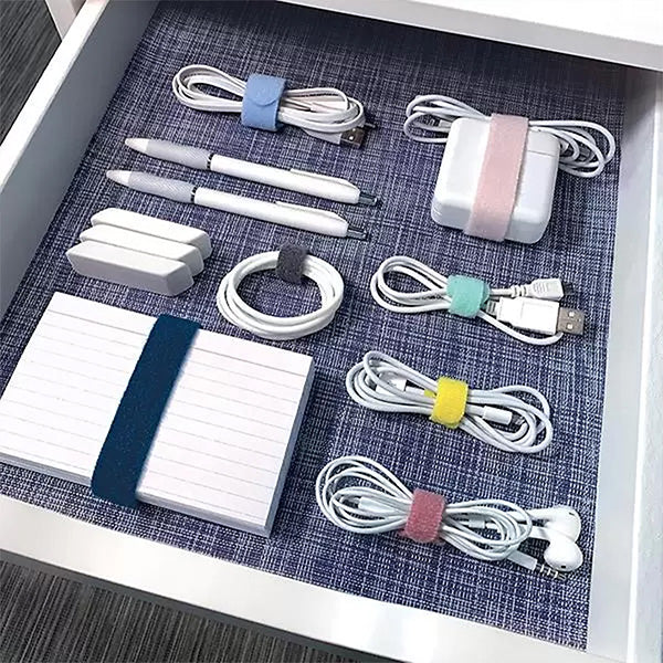 Drawer with USB chargers and AC plugs wrapped in individual colored cable ties for cord organization.