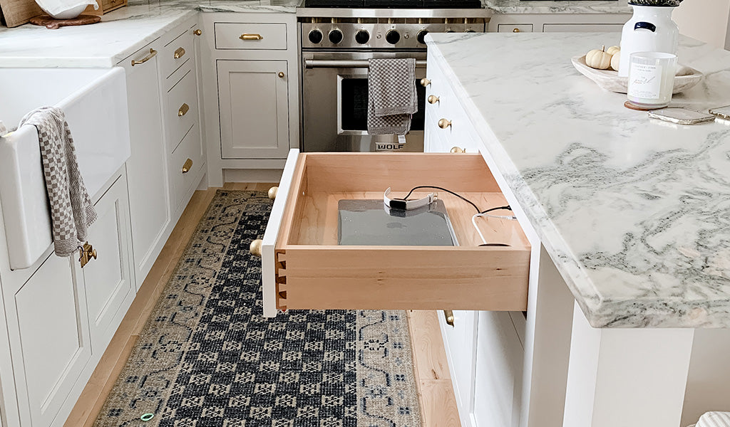 Contemporary kitchen featuring white cabinetry and a kitchen island charging station.