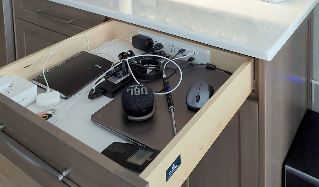 Wooden kitchen desk charging drawer station powering devices like a laptop, AirPods and a smartwatch.