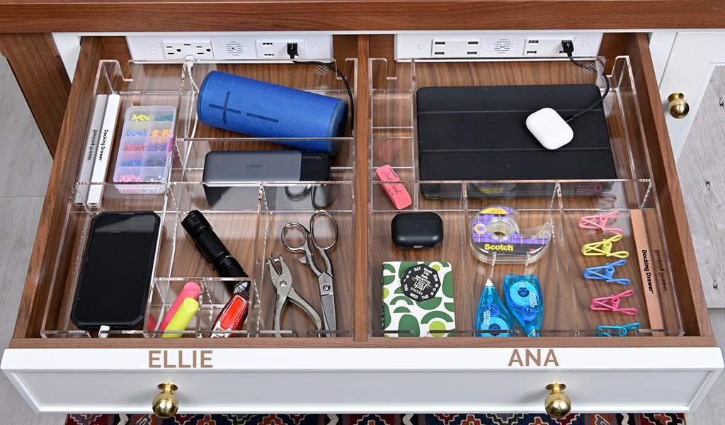 Kitchen drawer with two different drawer organizers, each storing tech devices charged via an in-drawer outlet.