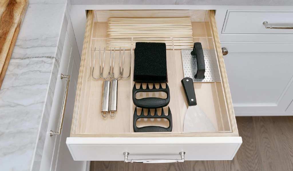 Kitchen drawer with a drawer organizer storing wooden skewers, meat claws and other grilling essentials.