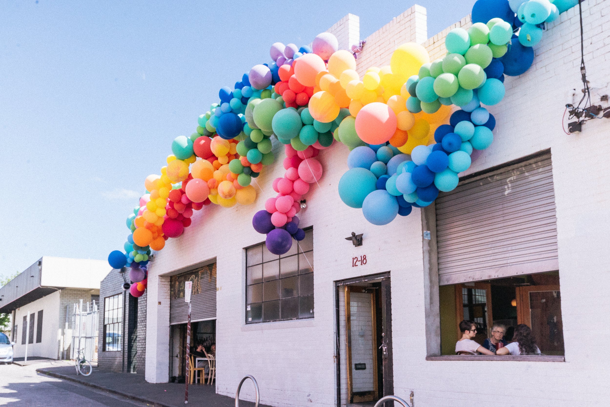 building with rainbow balloons assorted above