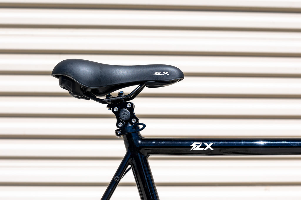 A detail photo of an FLX bike saddle on a Cane Creek suspension seat post mounted to an FLX babymaker II stealth e-bike