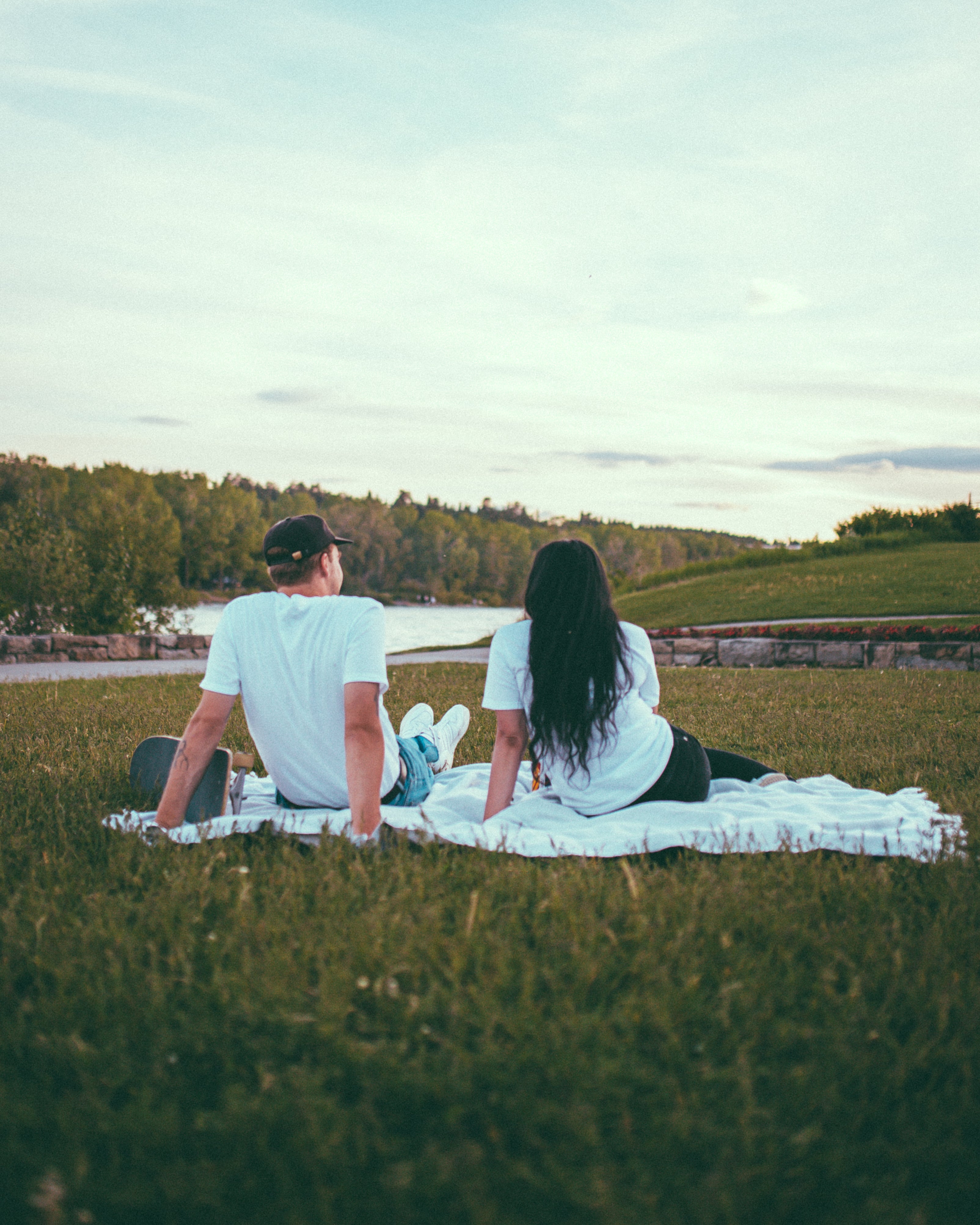 man and woman sitting by river in Calgary, AB