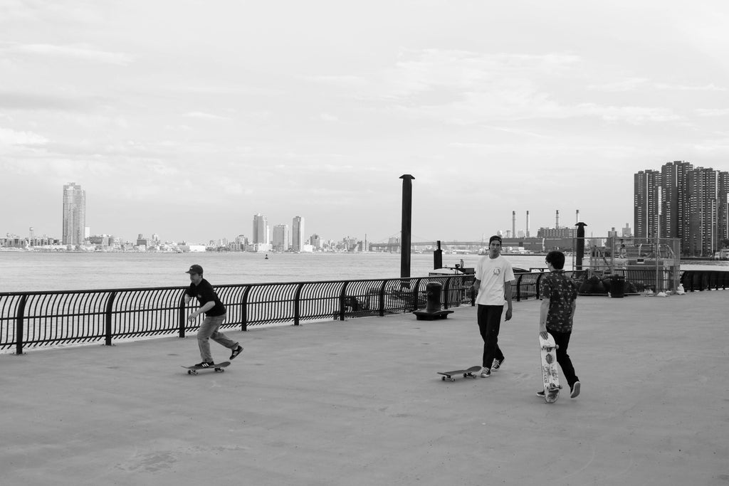 Friends pushing on skateboards in New York