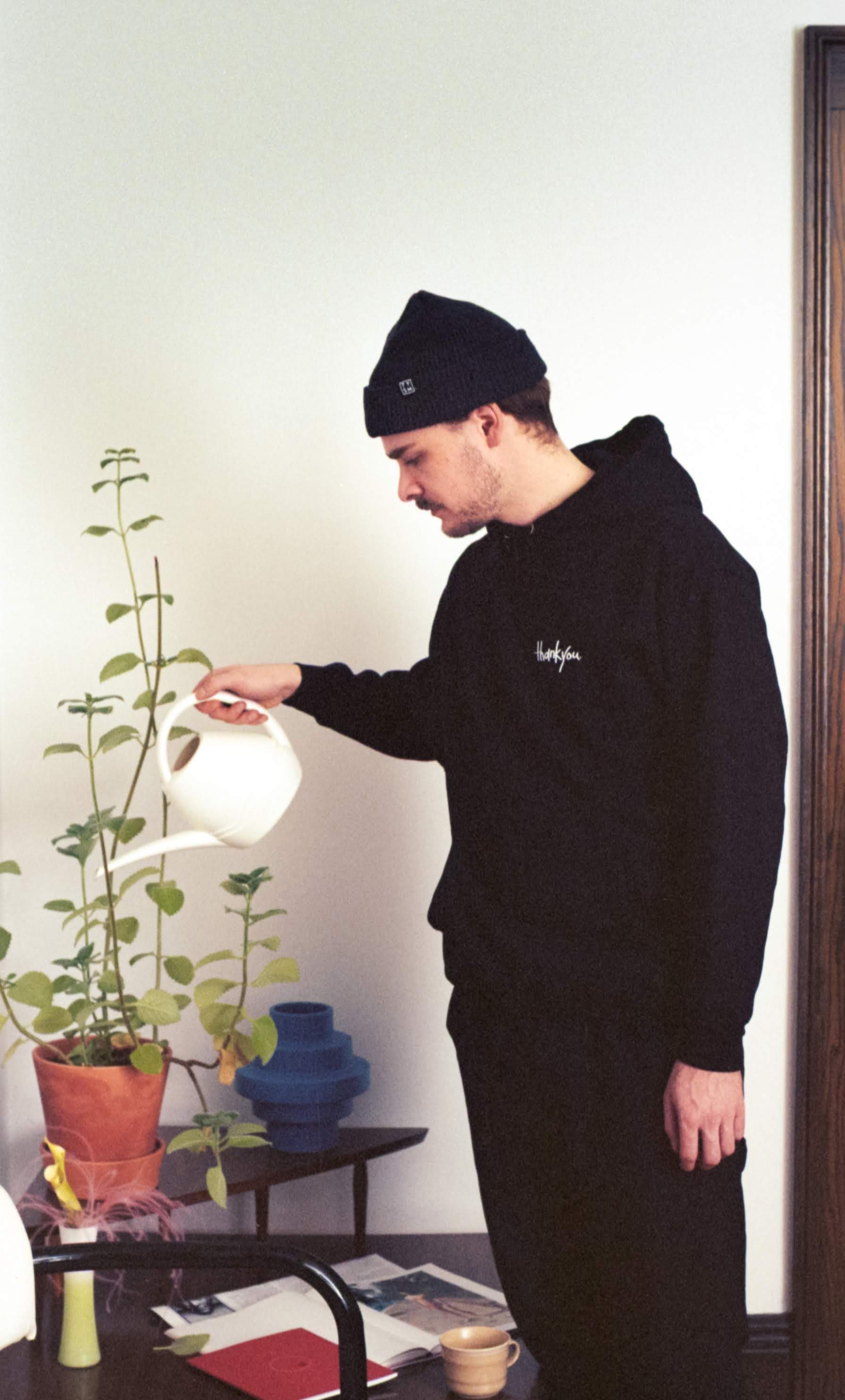 Friend watering a plant in a thankyou hoody