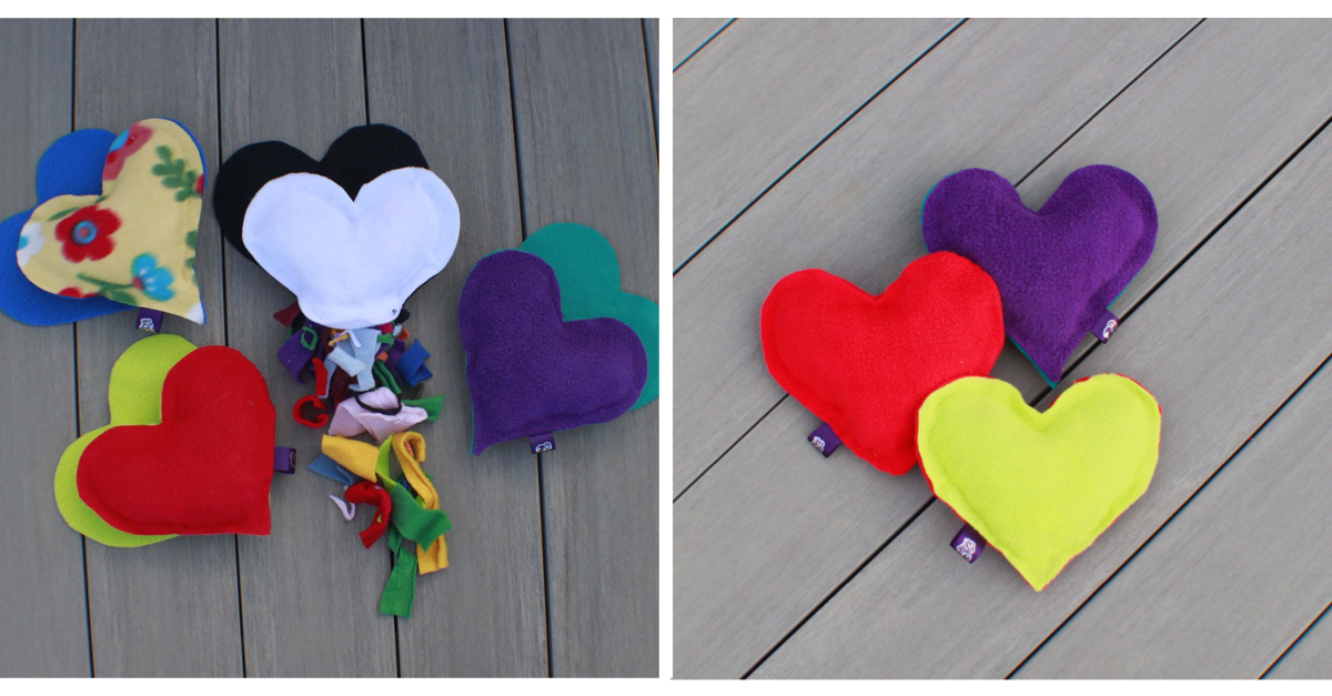 Colorful heart-shaped fabric toys on a wooden surface.