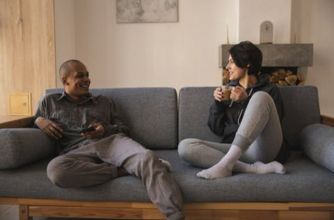 a couple sitting on the couch having a fun conversation