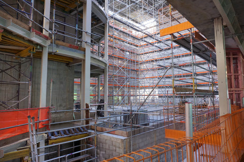 inside of building with scaffolding and orange restrictions