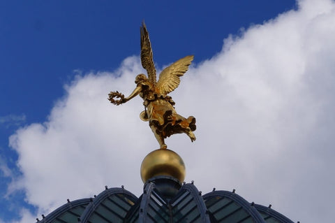 Brass angel holding a crown, statue on a roof. Academy of Fine Arts.