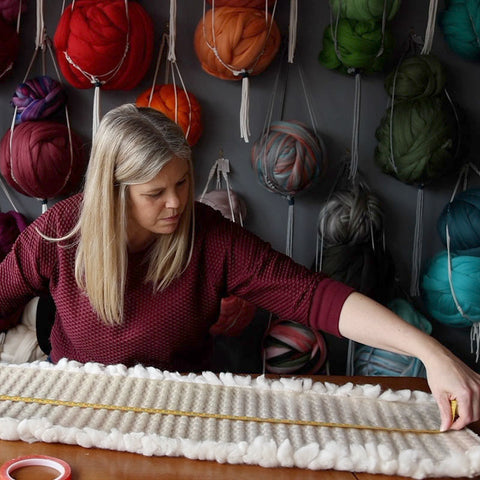 Cassandra Smith using her handwoven fabric and assembling a lampshade in her studio