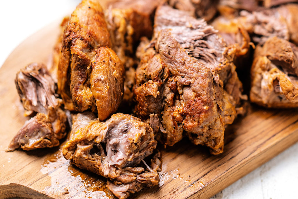 Slow cooker pulled pork on a wooden board.