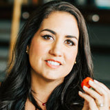 headshot of Cristina Crup holding a strawberry