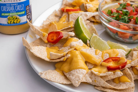 A plate of vegan nachos with Primal Kitchen Cheddar Cheez Style Sauce. 