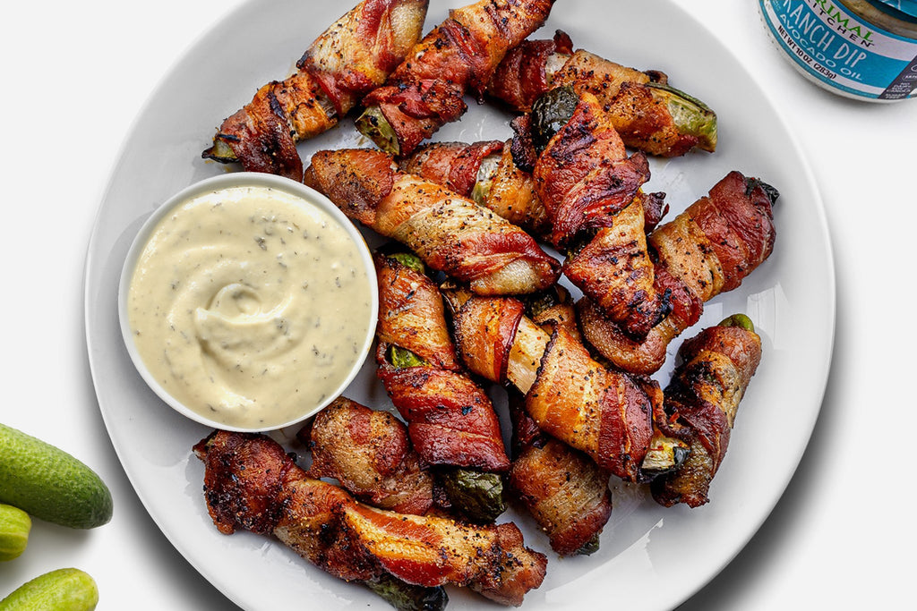 Bacon-wrapped pickles on a white plate