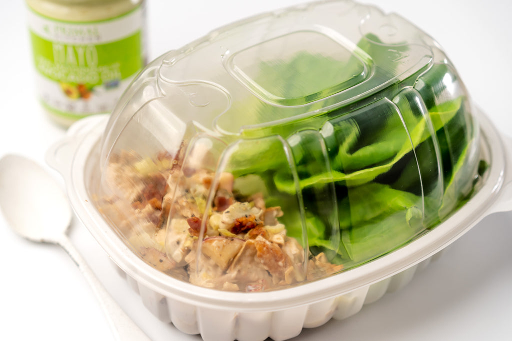 Rotisserie chicken salad and bibb lettuce leaves inside the upcycled rotisserie chicken container