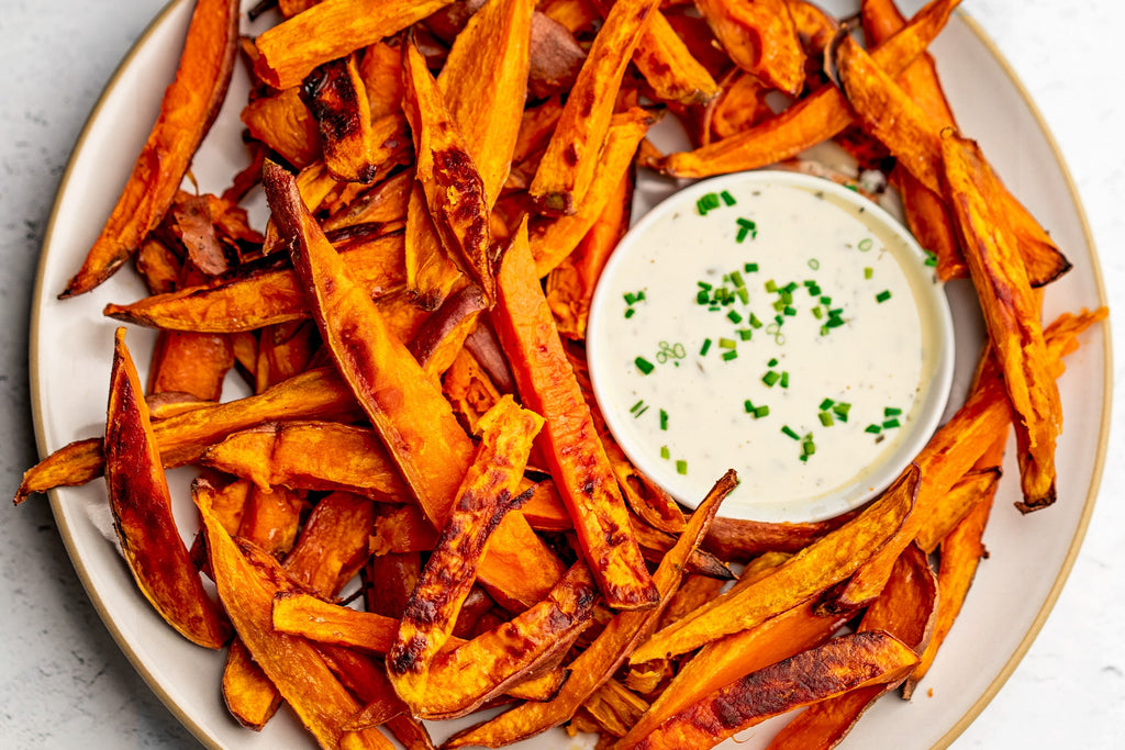 A white plate of sweet potato fries made with Primal Kitchen Avocado Oil