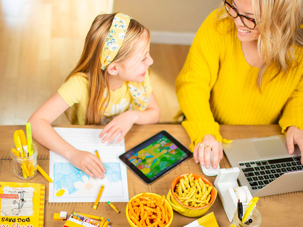 Mom and daughter doing school work and enjoying IWON Organics snacks