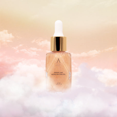 Image of Athr Beauty's Desert Skin Highlighting oil sitting on clouds with orangey background. 