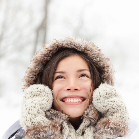 Image of smiling woman wearing winter coat and mittens on well&belle