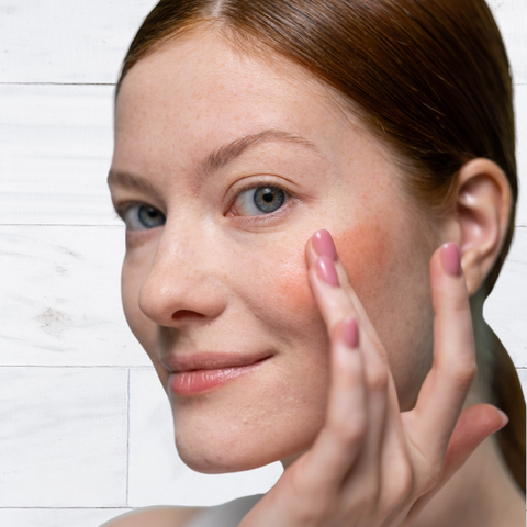 image on well&belle of woman applying cream blush to her cheek using her fingers 