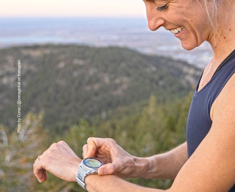 Mujer usando un GPS de muñeca en su entrenamiento de trail running