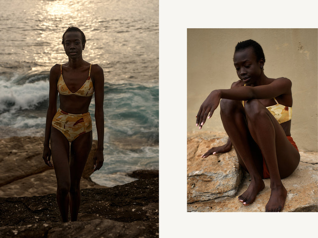 yellow studio of the sun print hakea bikini on model walking out of water with sunrise behind