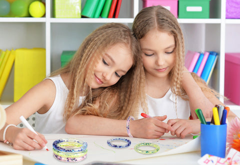 girls drawing and making friendship bracelets