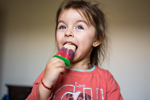 little girl eating popsicle