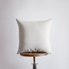 a white pillow sitting on top of a wooden table