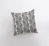 a pillow with a black and white leaf pattern on it