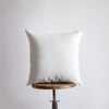 a white pillow sitting on top of a wooden table