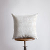 a white pillow sitting on top of a wooden table