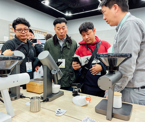 Acaia Co-Founder Rex showing the Orbit and Ion Beam to several SCA Expo 2023 attendees