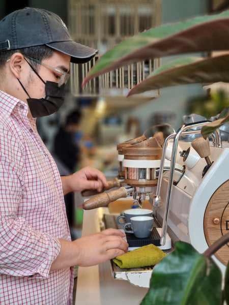 A barista brewing on an espresso machine