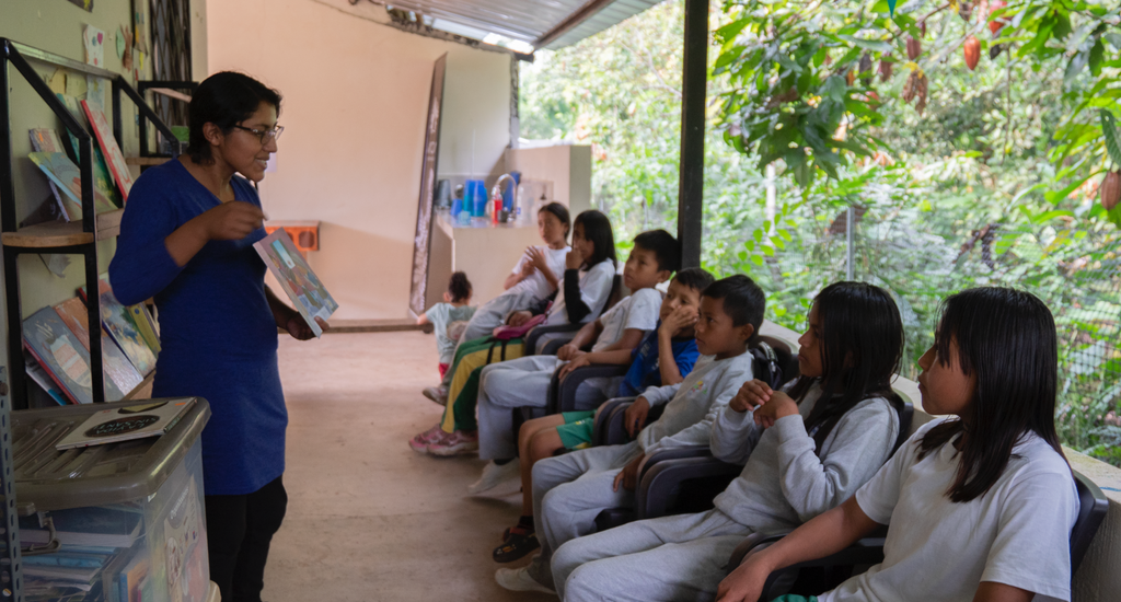 A teacher teaching some students in an outdoor class room area. Photo by Gabriel Granja