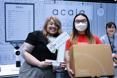 Acaia team member standing with winner of the Orbit grinder