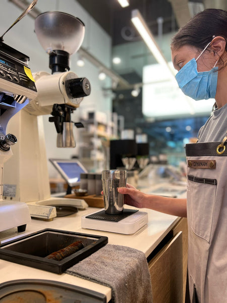 A barista checking the grinder