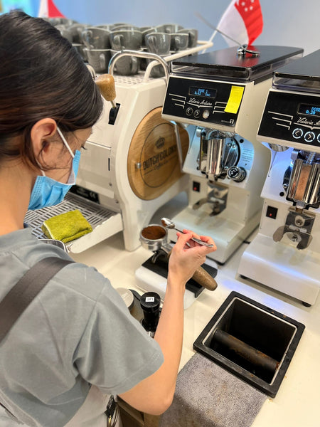 A barista weighing out coffee grounds on a Pearl scale