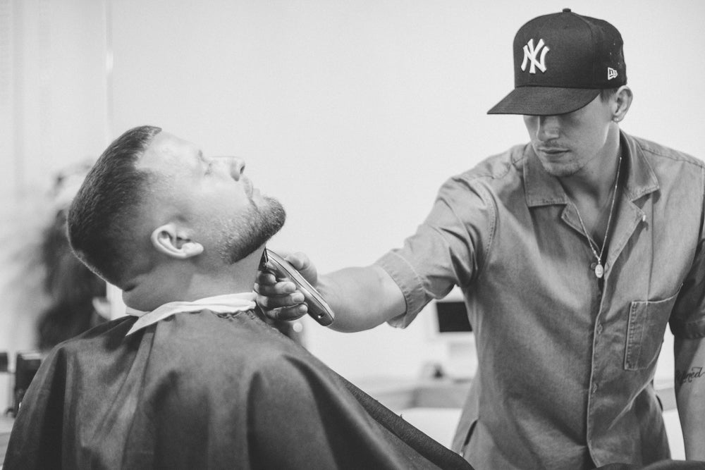 Austin shaving a customer's face.