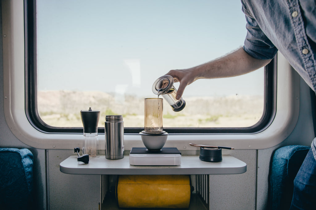 Vissers brewing an Aeropress coffee on a train.