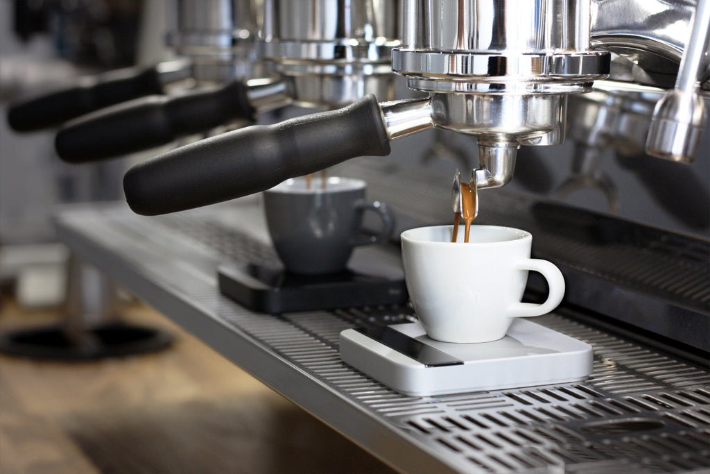 Both a Silver and Black Lunar on an espresso machine measuring espresso