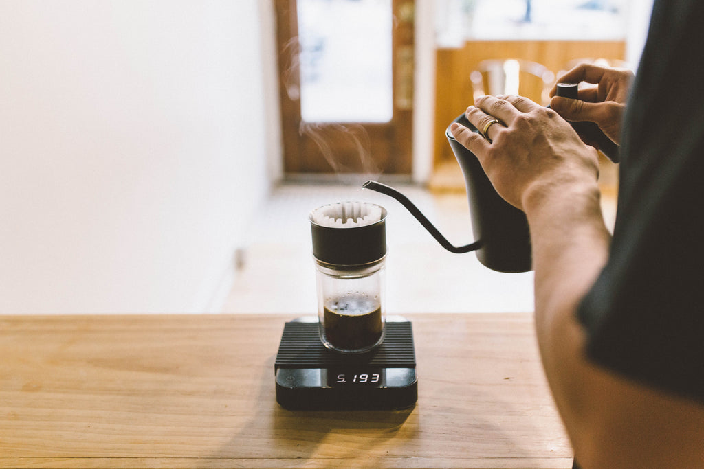 Brewing a filter coffee on top of a black Pearl scale with a Fellow kettle. 