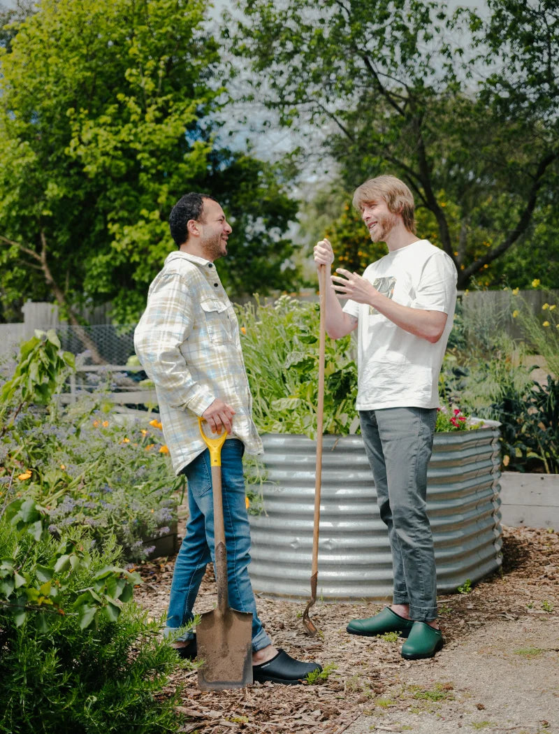 2 persons wearing clogs in the garden